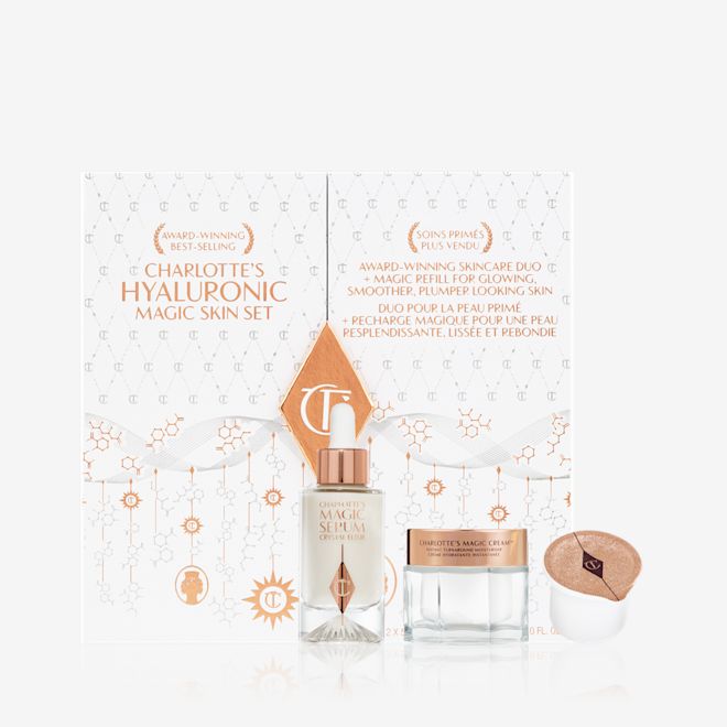 Hyaluronic Magic Skin Set displayed White and gold-coloured skincare box that includes a luminous face serum in a glass bottle and pearly white face cream in a glass jar with a gold-coloured lid that comes with a sample.