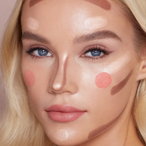 Model demonstrating the placements for Charlotte's liquid blush, blush-highlighter and contour wands
