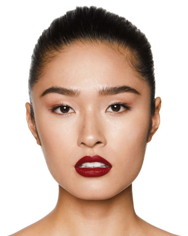 Fair-tone model with brown eyes wearing a muted wine-red lipstick with a satin finish.