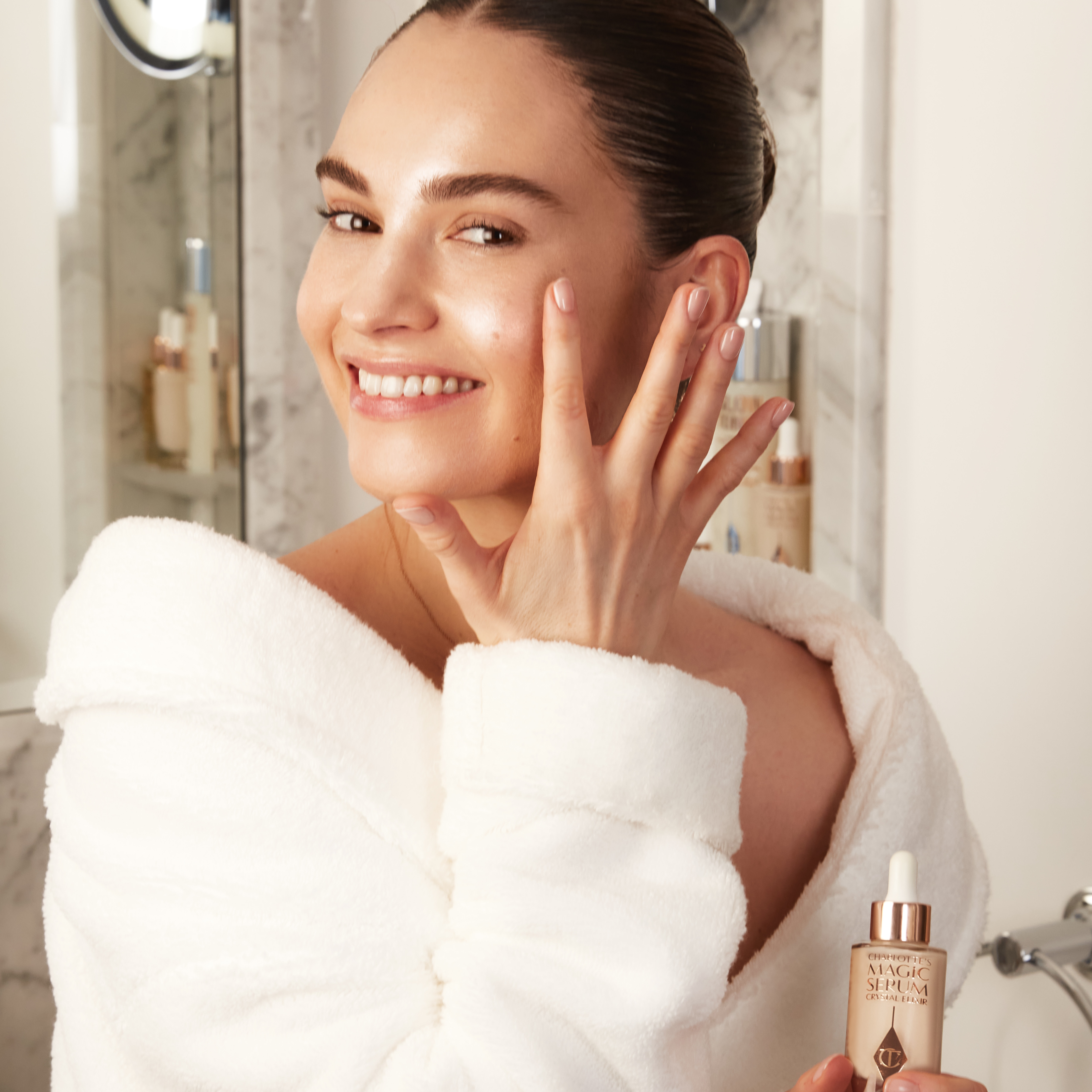 British actress Lily James applying Charlotte's Magic Serum Crystal Elixir face serum for gorgeous, glowing, hydrated skin