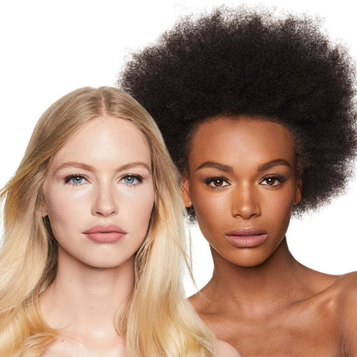 Close-up of a fair-tone blonde model and a deep-tone brunette model with flawless, glowy skin, wearing nude pink makeup. 