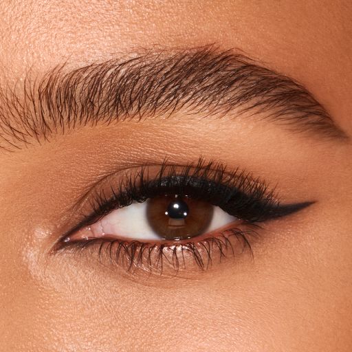 Eye close-up of a medium-skin model with brown eyes wearing a jet-black eyeliner in a soft wing. 