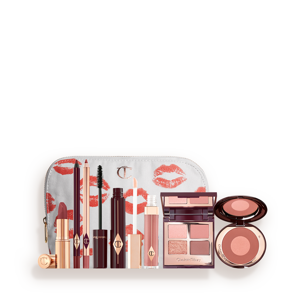 A white makeup pouch with open makeup products that are a berry-rose lipstick, maroon eyeliner pen, a rose-pink lip liner pencil, mascara, nude-pink lip gloss, a quad eyeshadow palette in earthy tones, and a two-tone blush in warm pink. 
