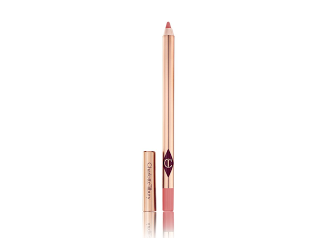 A lip liner pencil in a warm pink shade with its lid next to it. 