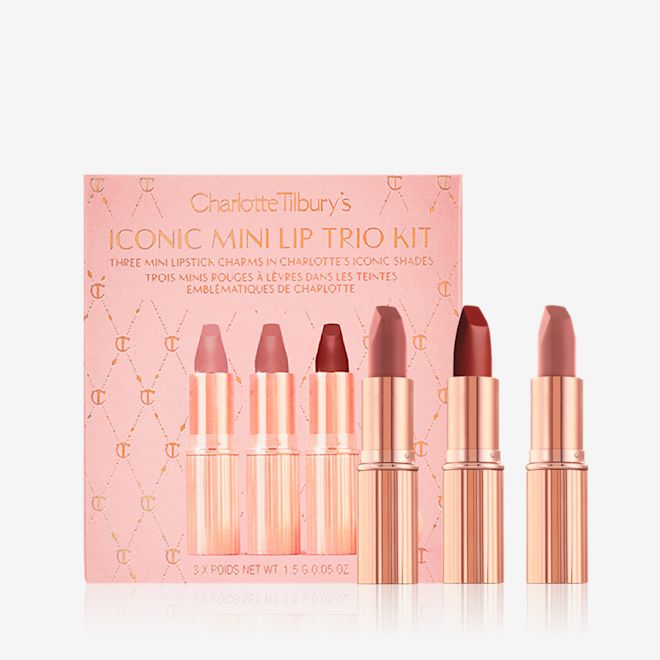 Iconic Mini Lip Trio with packaging displayed Three mini lipsticks in different shades of nude in gold-coloured tubes with a pink-coloured makeup box.