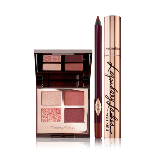 An open, quad eyeshadow palette with shades of cranberry and gold  with a berry-brown eyeliner pen, and black mascara in gold packaging.