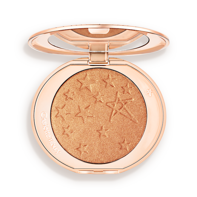 Hollywood Highlighter in Sunset Glow open An open highlighter powder compact with a mirrored lid, in a shimmery copper-gold shade.