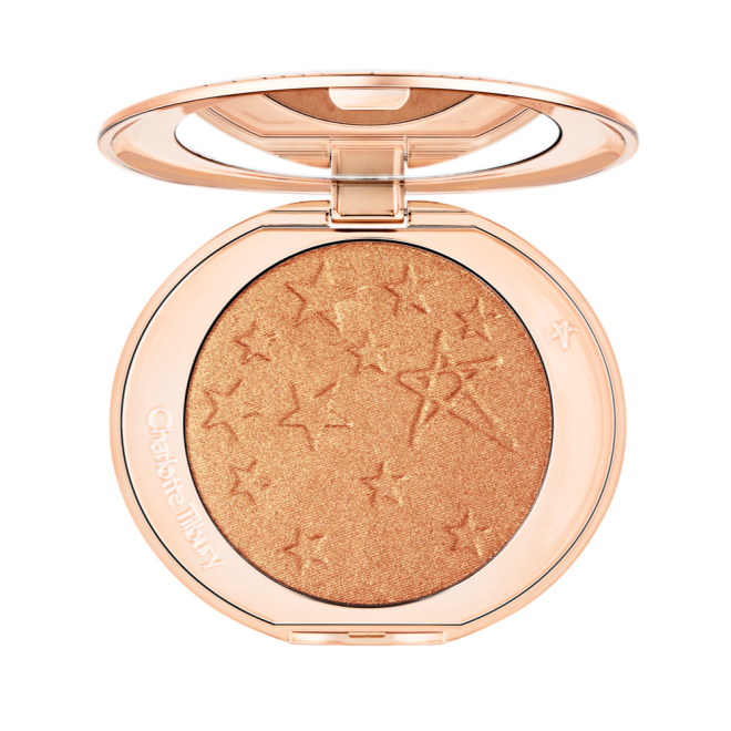 An open highlighter powder compact with a mirrored lid, in a shimmery copper-gold shade. 