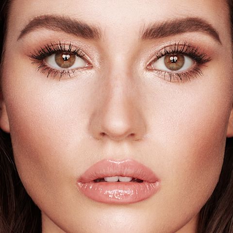 Nahaufnahme eines hellhäutigen Models mit Hazel-Augen, das einen schimmernden, roségoldenen Lidschatten und ein nuderosa Lipgloss trägt. 