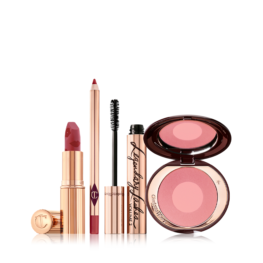 An open matte lipstick in berry pink with a rose-pink lip liner pencil, black mascara in gold packaging, and two-tone blush in a cool pink shade. 