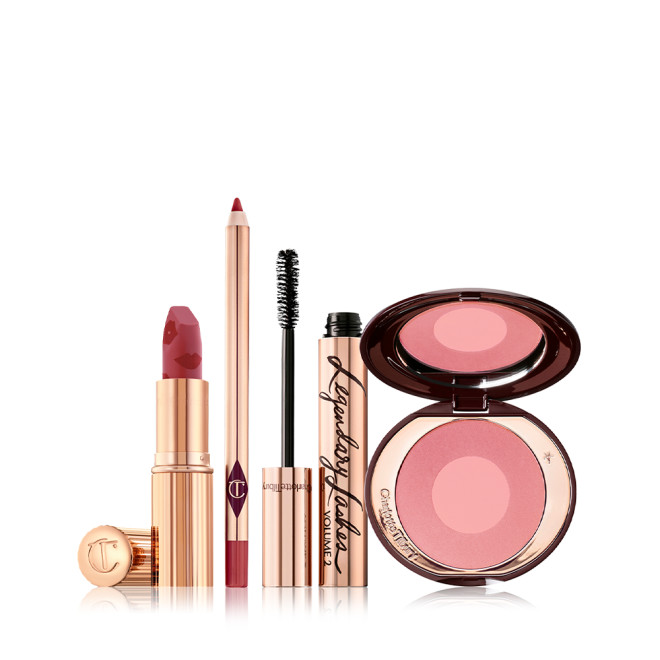An open matte lipstick in berry pink with a rose-pink lip liner pencil, black mascara in gold packaging, and two-tone blush in a cool pink shade. 