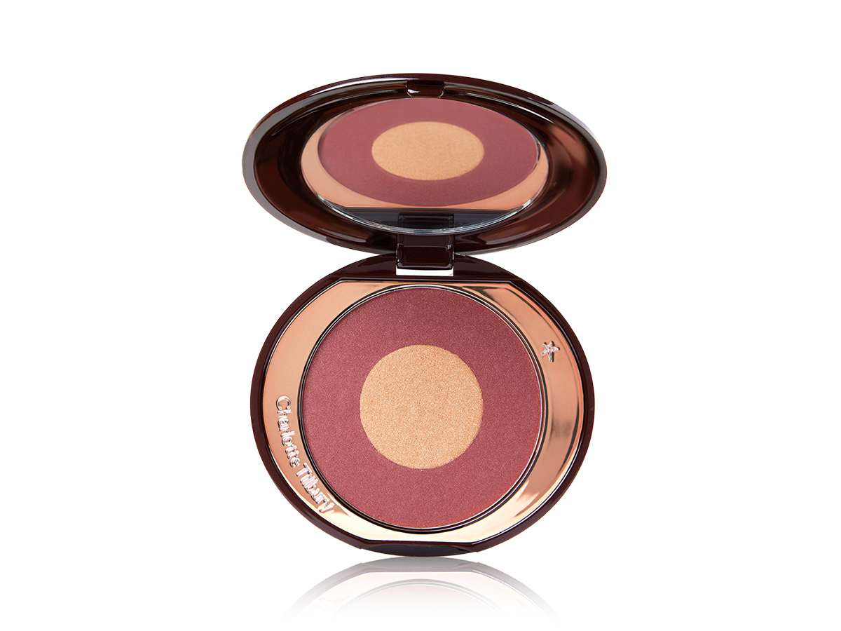 An open, two-tone powder blush compact in berry-pink and honey gold shades. 
