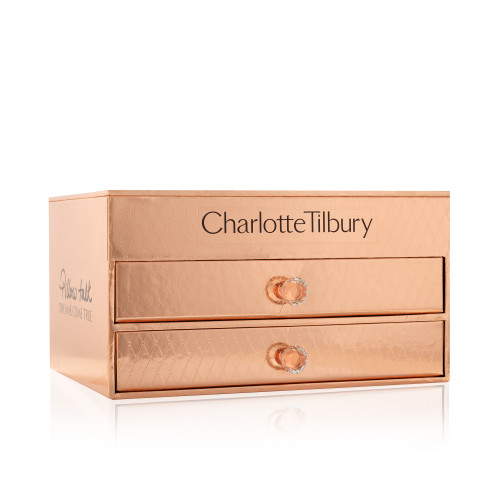 A reflective, gold-coloured chest with two drawers containing makeup and skincare items. 