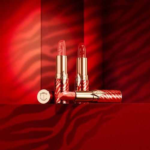 Three open lipsticks in red and gold, lunar-themed tubes in different shades of red with a matte finish. 