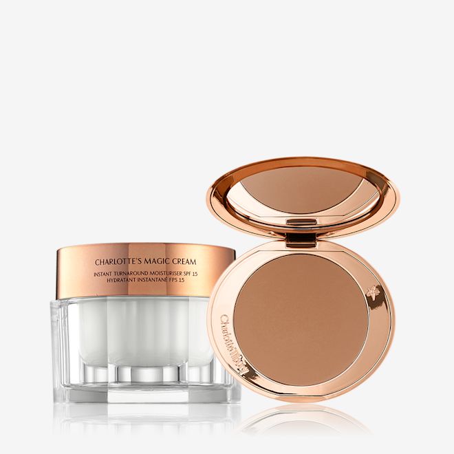 Airbrush Bronzer and Magic Cream Bundle dispalyed An open, mirrored-lid bronzer compact in a medium-brown shade with a thick, pearly-white face cream in a glass jar and rose-gold lid.