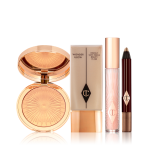 A highlighter compact with a mirrored-lid in a warm golden colour, foundation in a light beige shade with gold-coloured lid, lip gloss in a sheer pink shade with light gold coloured lid, and chubby eyeshadow stick in a dark bronze shade. 