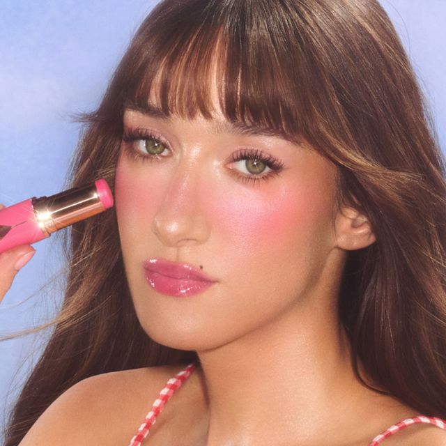 La modelo luce Unreal Blush Healthy Glow Stick en Pinky Glow