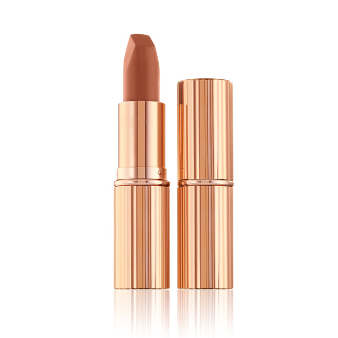 Two lipsticks, with and without lid, in a fresh, neutral nude peach matte shade, in sleek, gold-coloured tubes. 