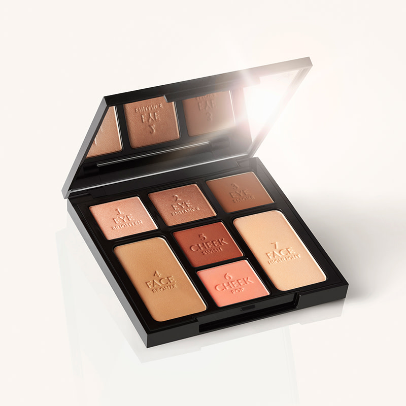 An open, mirrored-lid face palette with nude eyeshadows, nude pink and brown-pink blushes, bronzer, and highlighter. 