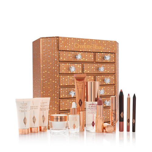 A golden-coloured chest with twelve drawers with shiny, silver-coloured star handles with the products inside displayed, hich include makeup primers, clay mask, face cream, liquid highlighter wand, setting spray, lipstick. mascara, chubby eyeshadow stick, lip liner pencil, and eyeliner.