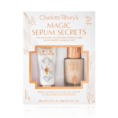Travel-size lip oil in a white-coloured tube with a gold-coloured lid and a mini, glow-enhancing serum in a glass bottle with a gold and white-coloured dropper lid packed in their gift sleeve in white colour with the text, 'Magic serum secrets' written on it'.