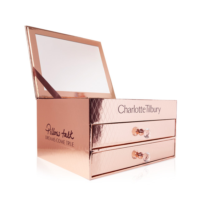 A golden-coloured open makeup kit with a mirrored lid and two pull-out drawers. 