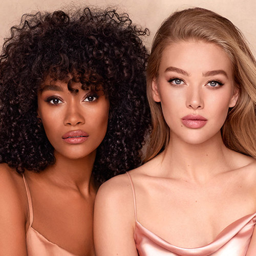 Models with deep, tan, medium, and fair skin tones wearing glowy, smoothing foundations with nude pink makeup. 