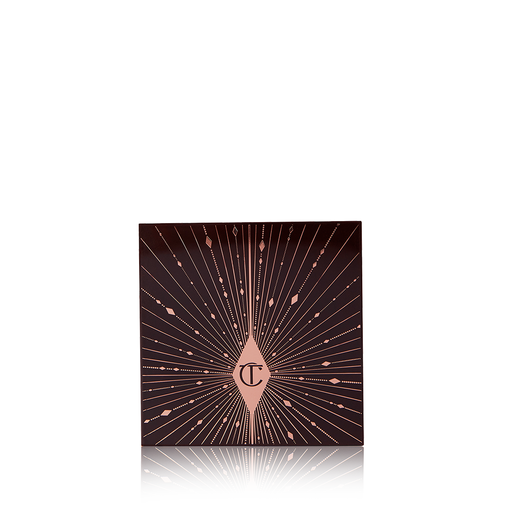 A closed eyeshadow palette with a black-coloured lid with pink-coloured glowy stars printed all over, giving it a starry-night look. 