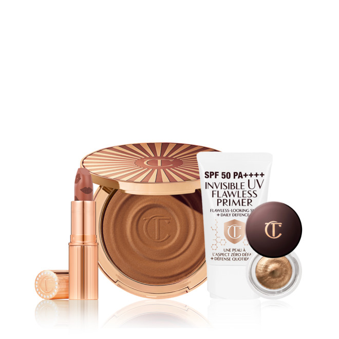 An open nude terracotta lipstick in golden-coloured packaging, open cream bronzer compact in a dark brown shade, SPF-infused primer in white packaging, and cream eyeshadow in a dark gold shade with a dark brown lid.