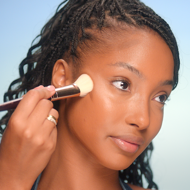 Model having cream bronzer applied to her cheekbones