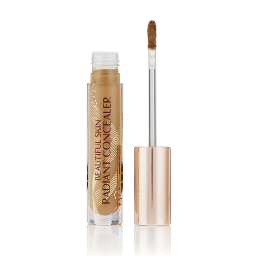 An open concealer in a dark brown shade in a glass tube with its doe-foot applicator next to it.