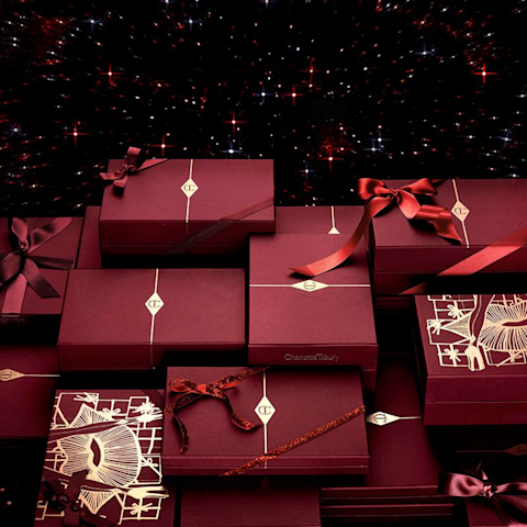 An array of intricately packaged gifts in crimson and golden wrapping with the CT logo printed on them.