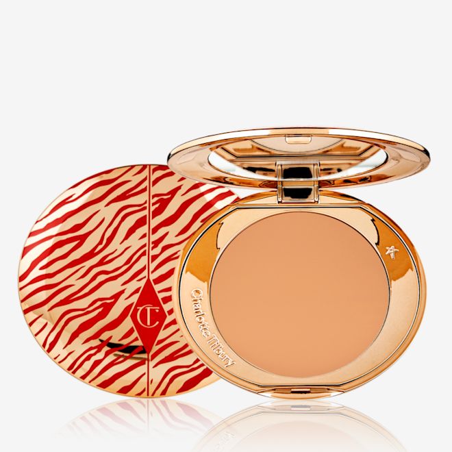 Airbrush Flawless Finish Powder in Tan Lunar New year open An open, pressed powder compact for tan skin tones with a mirrored lid, in gold-coloured packaging with red-coloured tiger stripes on the lid.