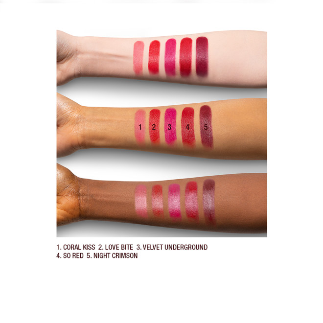 Light, tan, and deep-skin arm swatches of satin-finish lipsticks in shades of light, warm, and dark red. 