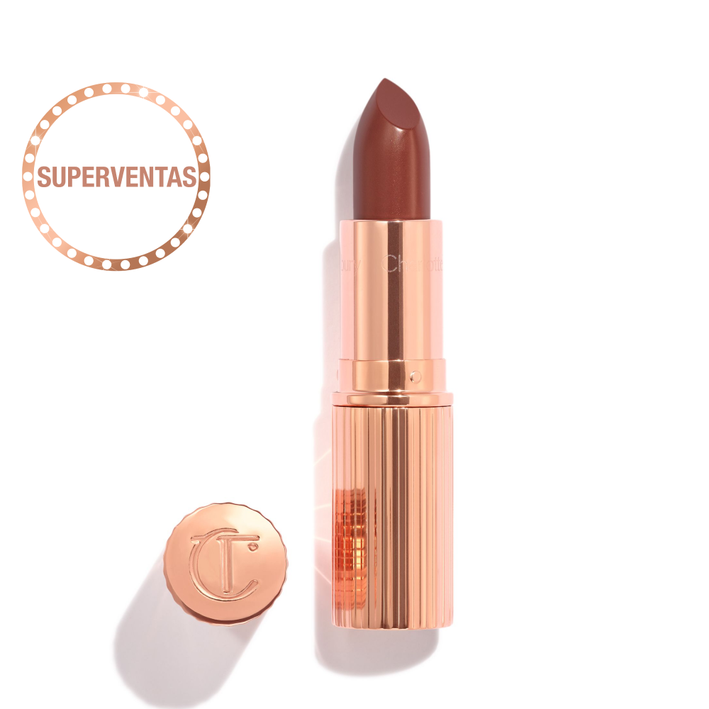 Abierto, labial rojo baya en un contenedor metálico dorado con su tapa, que tiene las letras CT en relieve, colocada a un lado. 