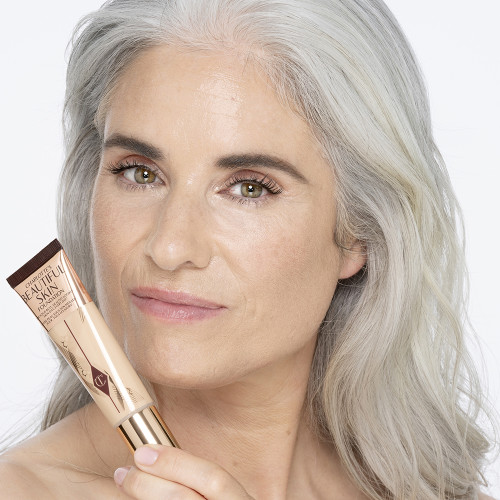 Light-tone model with glowy, flawless skin, wearing skin-like foundation that adds a youthful glow and looks natural along with nude pink lipstick and subtle everyday eye makeup.
