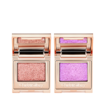 Two, single eyeshadow compacts in gold packaging with mirrored lids in shades of rose gold and duocrome purple.