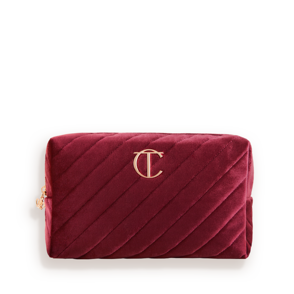 Red velvet makeup bag with the CT logo on the top in golden colour.