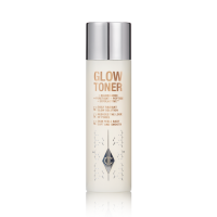 A large, clear bottle filled with luminous, cream-coloured watery toner with a silver-coloured lid.