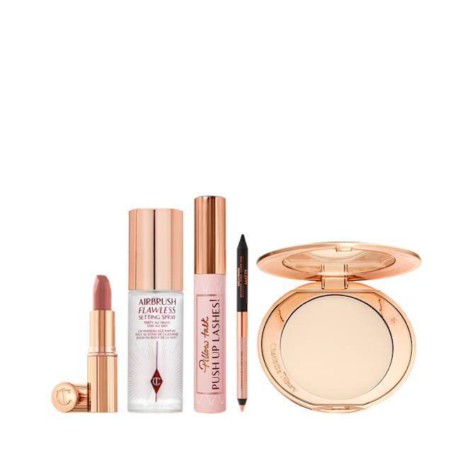 Filmstar On the Go makeup kit displayed Open lipstick tube in nude pink, setting spray in a clear bottle with a gold-coloured lid, black mascara in a nude pink tube with a gold-coloured lid, double-sided eyeliner in nude beige and black, and an open setting powder compact with a mirrored-lid.