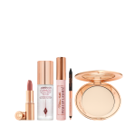 Open lipstick tube in nude pink, setting spray in a clear bottle with a gold-coloured lid, black mascara in a nude pink tube with a gold-coloured lid, double-sided eyeliner in nude beige and black, and an open setting powder compact with a mirrored-lid.