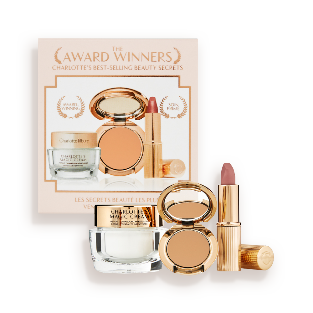 Pearly-white face cream in a glass jar with a gold-coloured lid, pressed powder compact in a tan shade, and a dusky pink lipstick in a sleek gold-coloured tube.