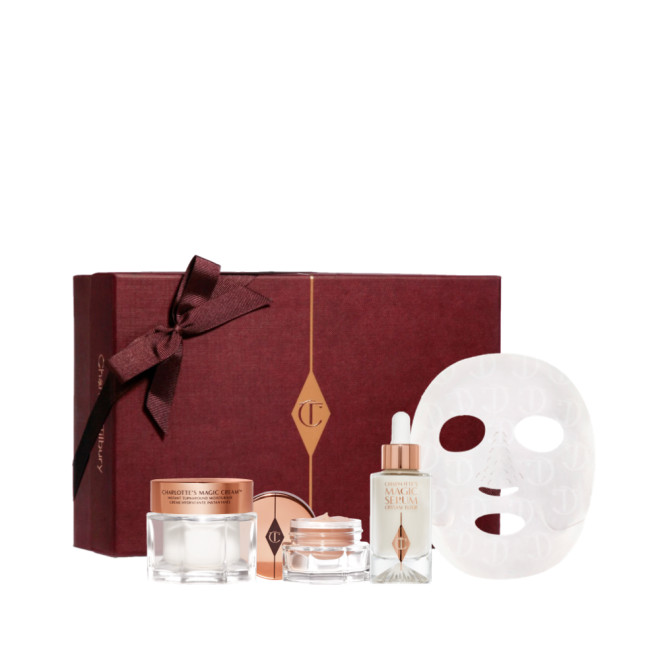 Eye cream in an open glass pot with a gold-coloured lid, dry sheet mask, luminous, ivory-coloured serum in a glass bottle with a white and gold-coloured dropper lid, pearly-white face cream in a glass jar with a gold-coloured lid, along with a light pink-coloured makeup sleeve with text in rose gold on it that reads, 'you are my star. I love you'