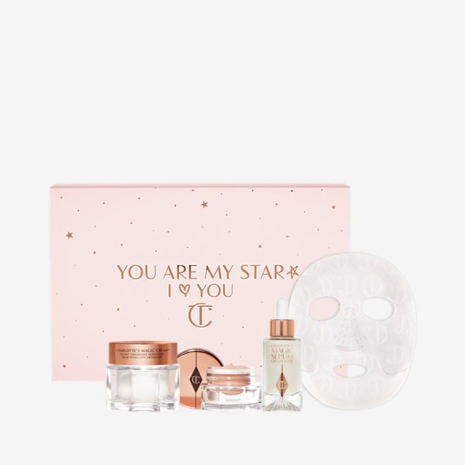 Glowing Night In Box with sleeve Eye cream in an open glass pot with a gold-coloured lid, dry sheet mask, luminous, ivory-coloured serum in a glass bottle with a white and gold-coloured dropper lid, pearly-white face cream in a glass jar with a gold-coloured lid, along with a light pink-coloured makeup sleeve with text in rose gold on it that reads, 'you are my star. I love you'