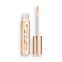 Light beige radiant concealer in a glass tube with its gold-coloured lid with a doe-foot end next to it, and text on the tube that reads, 'Beautiful Skin Concealer'