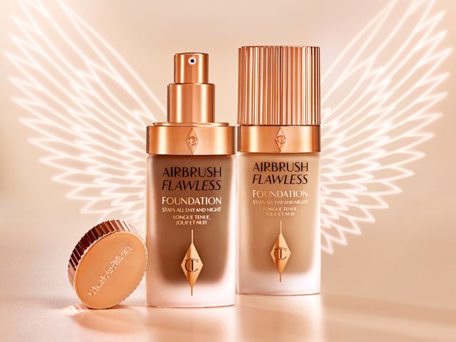 Dark and light foundations, one with its lid and the other with lid removed, in frosted glass bottles with gold-coloured pump dispensers and gold-coloured lids. 