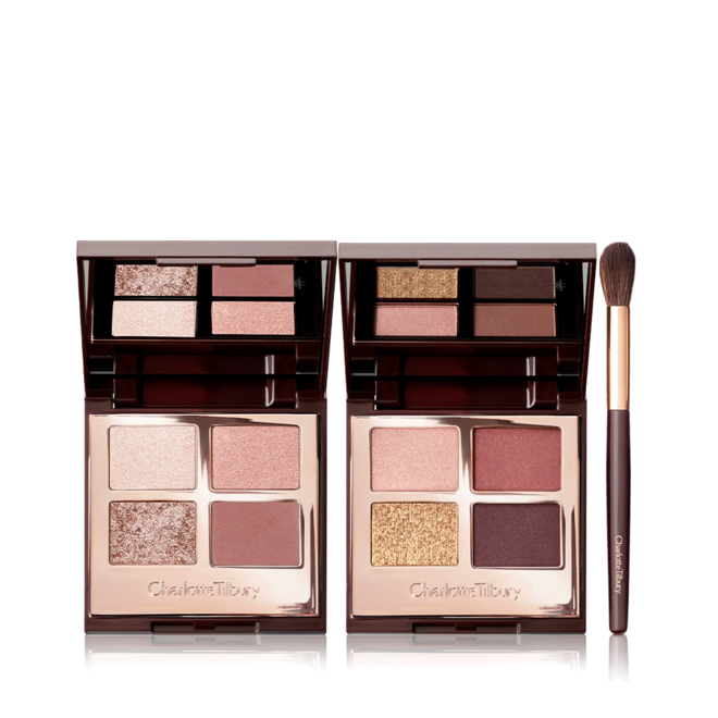 Two, quad eyeshadow palettes with mirrored-lids with eyeshadows in shades of pink, peach, gold, red, and brown along with an eyeshadow blending brush with soft brown-coloured bristles and a gold and brown-coloured handle.