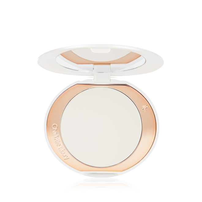 An open, setting powder compact with a mirrored-lid and white and gold-coloured packaging.