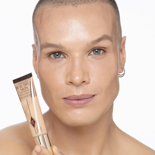 Light-tone male model wearing glowy, skin-like foundation with a fresh, satin finish.