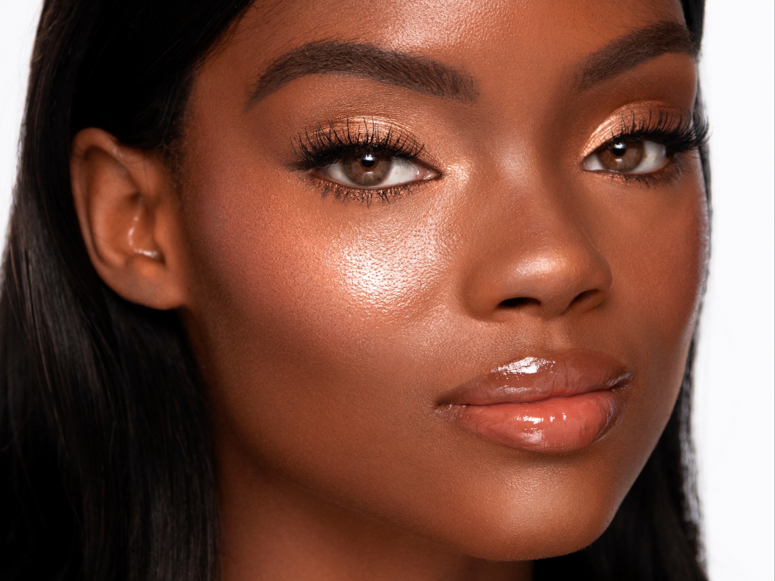 Ciera usando Beauty Light Wands en Pinkgasm y Goldgasm en la parte superior de los pómulos